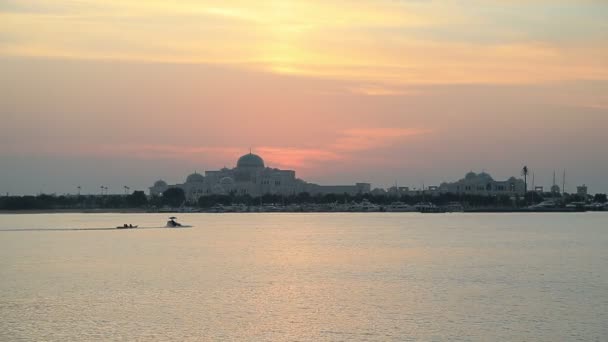 Mempesona matahari terbenam di Abu Dhabi di hari yang mendung dengan siluet perahu di laut — Stok Video