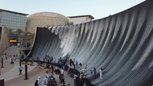 Dubai, Verenigde Arabische Emiraten - 28 november 2021: Watervoorziening op Expo 2020 in Dubai, toeristen genieten van majestueuze waterval — Stockvideo