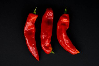 Siyah arka planda taze kırmızı tatlı biberler.