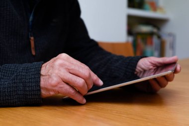 Olgun eller, evde bağlı kalmak için dokunmatik ekran tableti aygıtını tutsun
