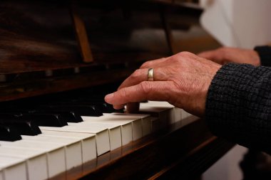 Olgun erkek eller piyano çalarken ellere ve klavyeye odaklanır.