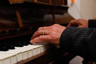 Olgun erkek eller piyano çalarken ellere ve klavyeye odaklanır.