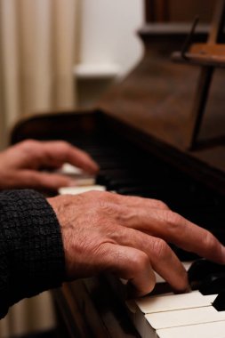 Olgun erkek eller piyano çalarken ellere ve klavyeye odaklanır.