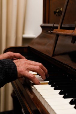 Olgun erkek eller piyano çalarken ellere ve klavyeye odaklanır.