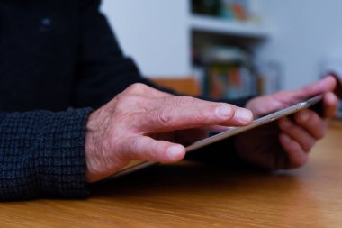 Olgun eller, evde bağlı kalmak için dokunmatik ekran tableti aygıtını tutsun