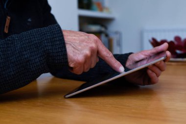 Olgun eller, evde bağlı kalmak için dokunmatik ekran tableti aygıtını tutsun