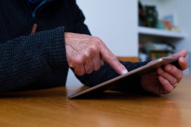 Olgun eller, evde bağlı kalmak için dokunmatik ekran tableti aygıtını tutsun
