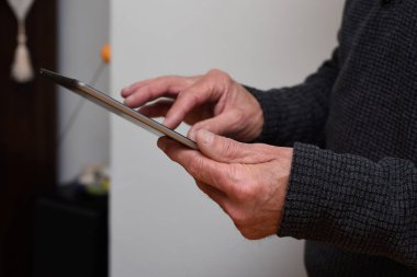 Olgun eller, evde bağlı kalmak için dokunmatik ekran tableti aygıtını tutsun