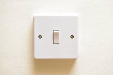 Beyaz bir duvarda ışık düğmesi