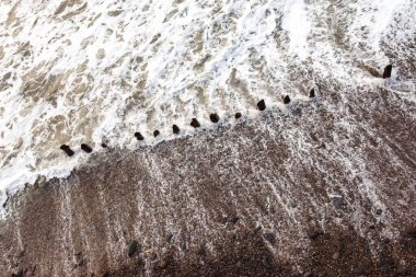 Deniz suyu, çakıl taşlarının üzerinden soyut bir şekilde akıyor.