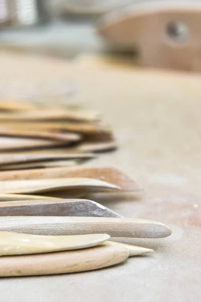 Wooden pottery tools set on a ceramics studio background