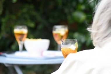 Güneşli bir günde dışarıda kokteyl içen insanlar.