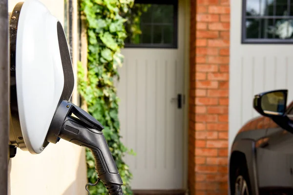 Coche Eléctrico Enchufado Para Cargar Fuera Casa Con Cable Alimentación Imagen de stock