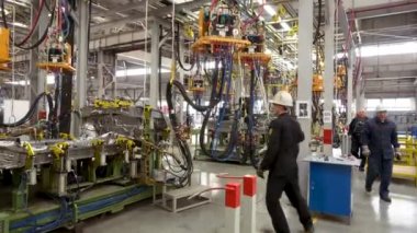 İşçiler araba parçalarını kaynaklıyor. Otomobil fabrikası, otomobil üretim süreci.