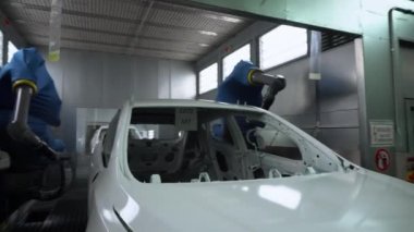Robotik kollar tarafından bembeyaz boyanmış bir araba.