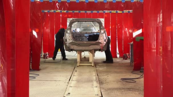 Industrie manufacturière automobile. Homme soudant des pièces de voiture sur la ligne de production — Video