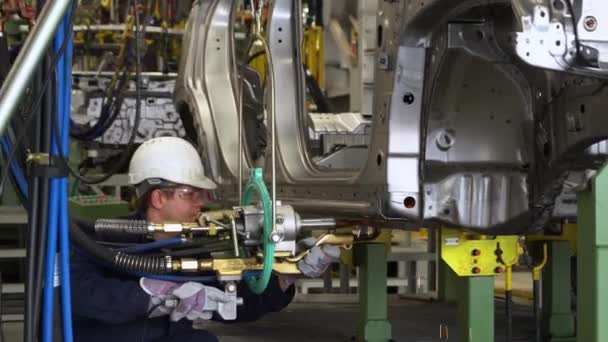 車の工場の男は車の部品を溶接。自動車整備士. — ストック動画
