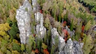 Kayalık tepelerin ve sarı yeşil sonbahar ormanlarının havadan görünüşü. Bir sonbahar günü, dağların üzerinden peyzaj uçuşu. Rusya 'da Ural Sırtı İlham verici doğa