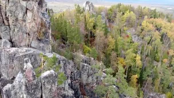 从空中俯瞰岩石山峰和黄绿的秋天森林 风景无人机在秋天的一天飞越高山 俄罗斯的乌拉尔山脊 — 图库视频影像