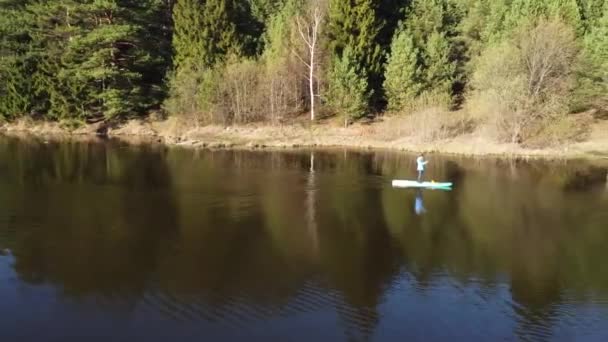 森の湖の上でボードに乗っている女の子 — ストック動画