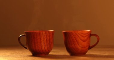 Kahveli tahta bardak. Buhar sıcak kahve, çikolata ve çaydan geliyor. Arka planda Noel ışıkları var. Noel yaklaşıyor.