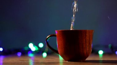 Kahveli tahta bardak. Buhar sıcak kahve, çikolata ve çaydan geliyor. Arka planda Noel ışıkları var. Noel yaklaşıyor.