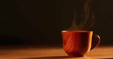Kahveli tahta bardak. Buhar sıcak kahve, çikolata ve çaydan geliyor. Arka planda Noel ışıkları var. Noel yaklaşıyor.
