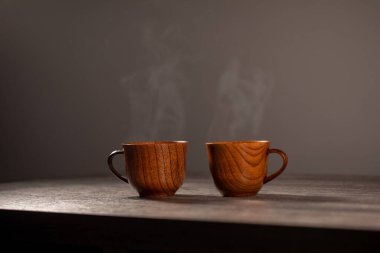 Kahveli tahta bardak. Buhar sıcak kahve, çikolata ve çaydan geliyor. Arka planda Noel ışıkları var. Noel yaklaşıyor.