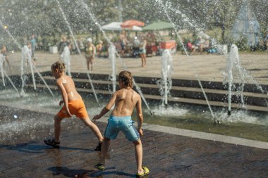 Çocuklar sıcak yaz gününde Rusya 'da Saint-Petersburg' da şehir çeşmesinde koşup oynuyorlar. Yüksek kalite fotoğraf