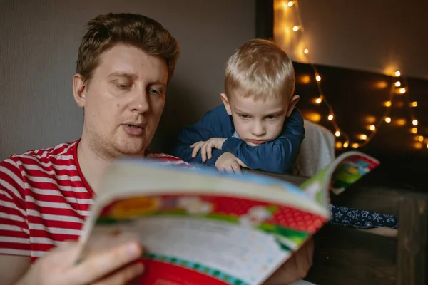 Πατέρας Διαβάζει Χριστουγεννιάτικο Βιβλίο Στον Χαριτωμένο Γιο Του Πρωτοχρονιά Γιορτή — Φωτογραφία Αρχείου
