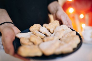Kadının elinde kurabiye olan bir tabak. Noel tatili kavramı. Seçici odaklı resim