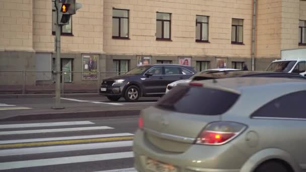 Автомобили начинают двигаться с зеленым светом на пешеходной дорожке. — стоковое видео