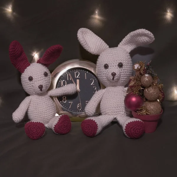 Yılbaşı kartı ve saat. Koyu arkaplanda el yapımı amigurumi bebekleri..