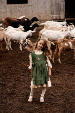 Çiftlikte yürüyen yeşil elbiseli şirin bir çocuğun portresi. 