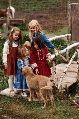 Çiftlikte köpeği olan güzel elbiseli şirin çocuklar. 
