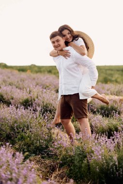 Güzel genç bir çift lavanta tarlasında yürüyor.