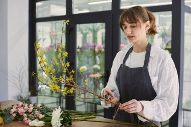 Güzel, genç bir çiçekçi buket yapıyor.
