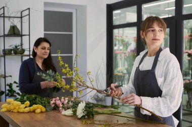Güzel, genç bir çiçekçi buket yapıyor.