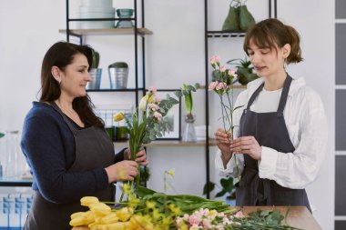 Güzel, genç bir çiçekçi buket yapıyor.