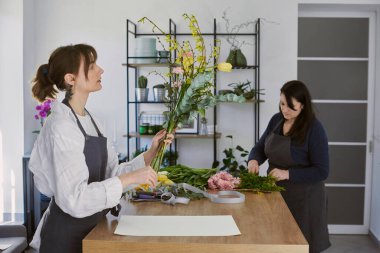 Güzel, genç bir çiçekçi buket yapıyor.