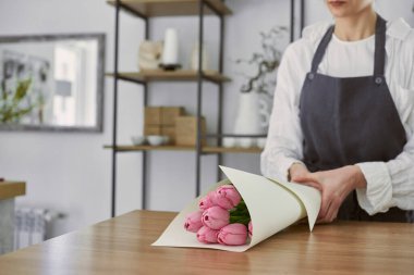 Güzel, genç bir çiçekçi buket yapıyor.