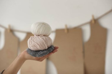 Eskizlerin arka planında iplik izleri tutan kadın.