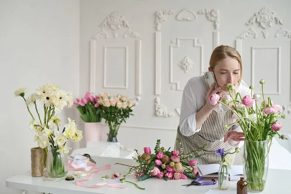 Dizüstü bilgisayar kullanan genç yaratıcı kadın bir çiçek dükkanında. Çiçekçi iş başlangıç.