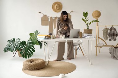 Terzi, kızıyla birlikte stüdyoda kıyafet yapıyor..