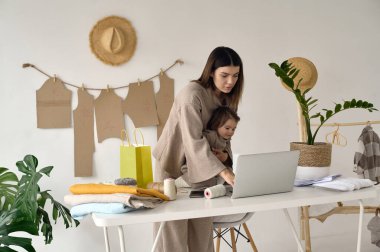 Terzi, kızıyla birlikte stüdyoda kıyafet yapıyor..