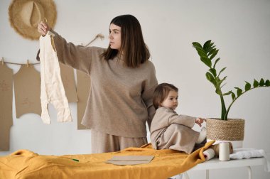 Terzi, kızıyla birlikte stüdyoda kıyafet yapıyor..