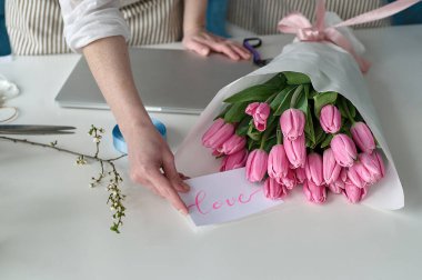 Takım çalışması. İki güzel çiçekçi bir buket oluşturuyor.