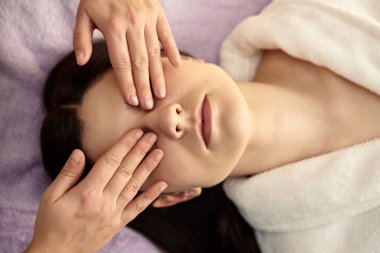 Sağlık ve güzellik, tatil köyü ve rahatlama konsepti - kaplıca salonundaki genç kadın masaj yaptırıyor