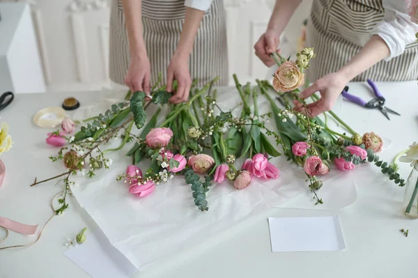 团队合作 两个年轻漂亮的花匠创造了一束花 — 图库照片