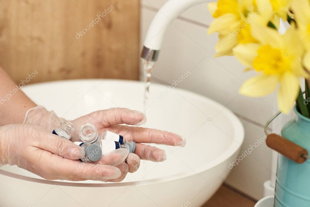 face correction ampules on a mwomen's hands under the tap
